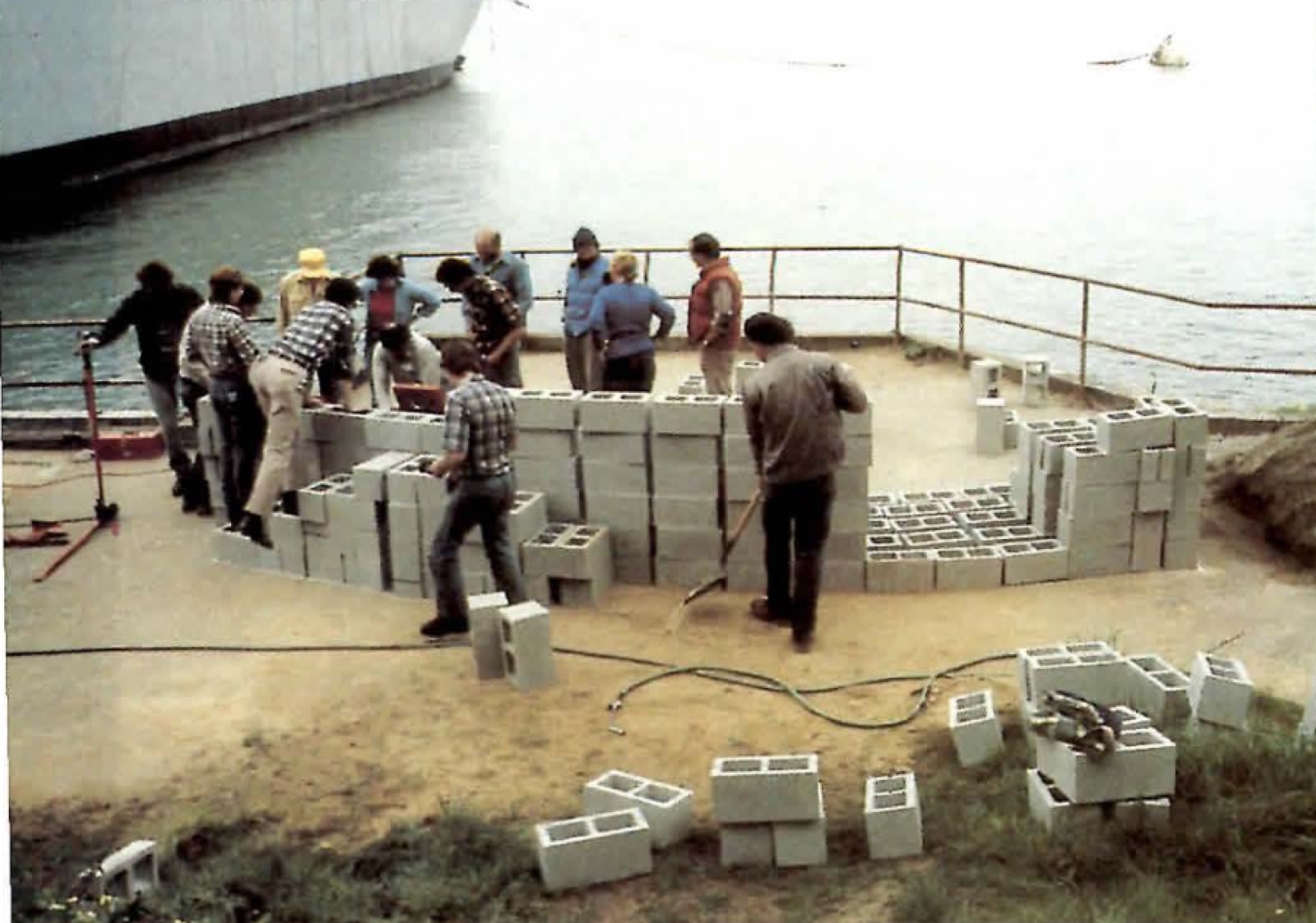 Participants arranging concrete blocks at the water’s edge to mock up the bench’s curve.